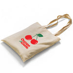 A high-quality canvas tote bag featuring the vibrant vintage cherry design. The bold print showcases a designer cherry logo with green leaves and branding, adding a retro, vintage vibe. The bag is photographed against a clean backdrop, highlighting its durability and stylish simplicity.