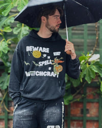 Model wearing Occupo Gloria vintage washed Halloween hoodie in rain with umbrella